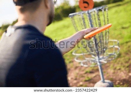 Man is preparing to throw disc to the basket in disc golf