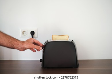 Man Preparing Toast For Breakfast In A Toaster