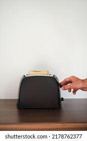 Man Preparing Toast For Breakfast In A Toaster