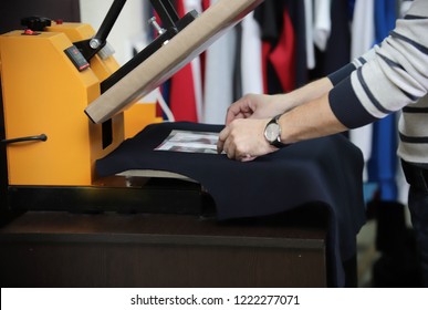 Man Preparing T-shirt For Printing In The Silk Screen Printing Machine. Only Hands