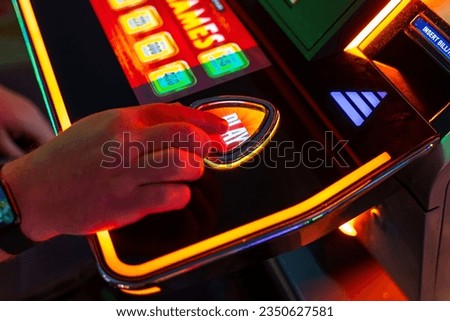 A man presses the button to play the slot machine. A man playing slot machine.