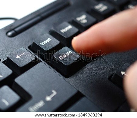 man presses the DELETE button on a black keyboard. the concept of breaking a relationship, destroying information. copy space.