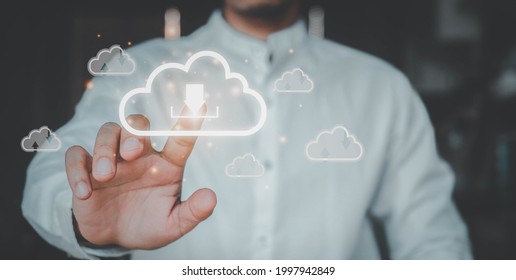 Man presses download button  cloud.Cloud computing is system for sharing download and upload big data information. - Shutterstock ID 1997942849