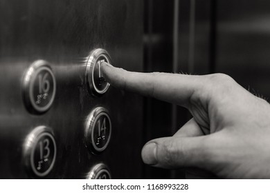the man presses the elevator button. black and white.
