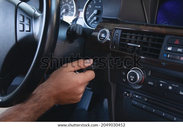 a man presses the\
start button in the car