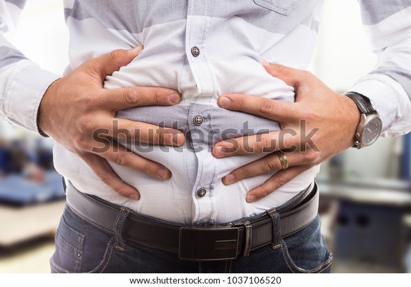 男子压抓腹腹部腹部或腹部为抽筋胀气便秘问题库存照片 立即编辑