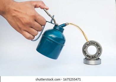 ็Hand of a man pressing the oiler pump into a bearing isolated on a white background