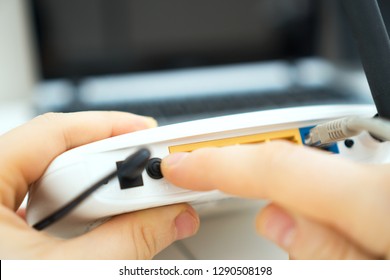 Man Pressing Power Button On The Wifi Router.