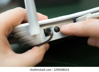 Man Pressing Power Button On The Wifi Router.