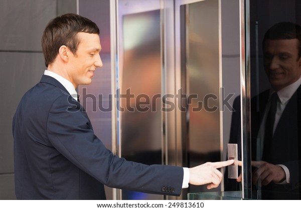 Man pressing red elevator button. side\
view of businessman pushing elevator button\
