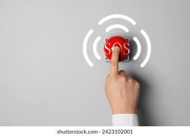 Man pressing red SOS button at white background, closeup