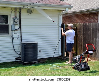 Man Pressure Washing His House