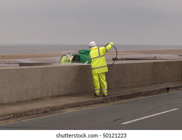 Man Pressure Washing A Wall