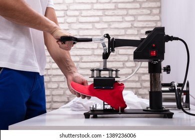 Man Printing On Baseball Cap In Workshop