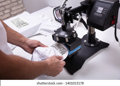 Man Printing On Baseball Cap In Workshop