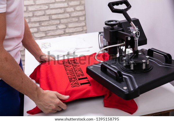 Man printing on t shirt\
in workshop