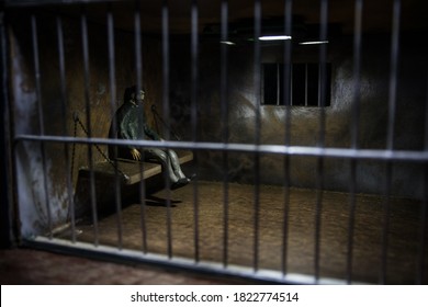 Man In Prison Man Behind Bars Concept. Old Dirty Grunge Prison Miniature. Dark Prison Interior Creative Decoration. Selective Focus