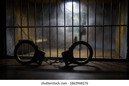 Man In Prison Man Behind Bars Concept. Old Dirty Grunge Prison Miniature. Dark Prison Interior Creative Decoration With Handcuffs. Selective Focus