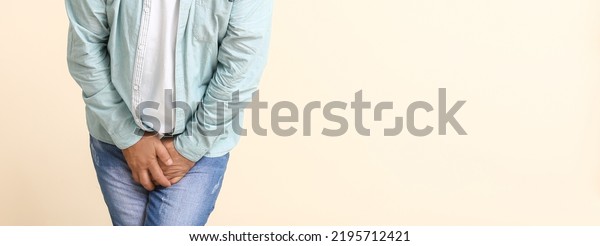 Man with problem of\
frequent urination on light background with space for text.\
Prostatitis concept