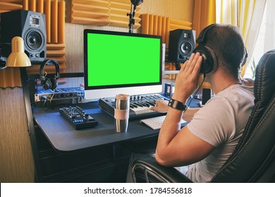 A Man Produce Electronic Music In Home Studio Using Headphones And Look In Green Screen On Monitor