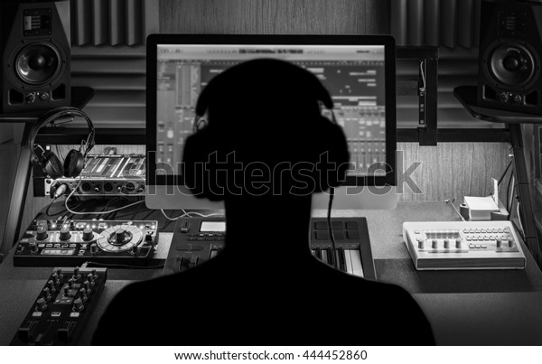 Man produce electronic music in\
project home studio. \
Silhouette. Black and white\
image.