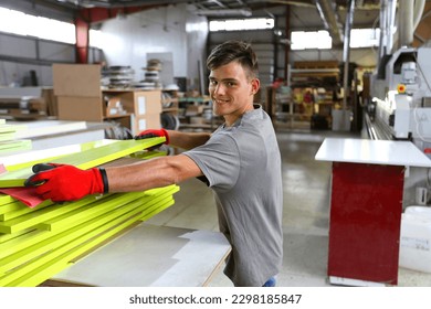 Man in production. Half-length portrait of a cheerful factory worker looking at the camera. Furniture manufacturing. - Shutterstock ID 2298185847