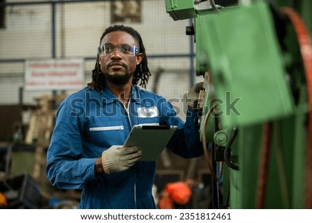 Man professional american african worker in heavy industry engineer wearing safety uniform using digital tablet working at industrial. Male manager checking system construction manufacturing.