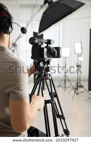 Man with professional video camera in studio, closeup