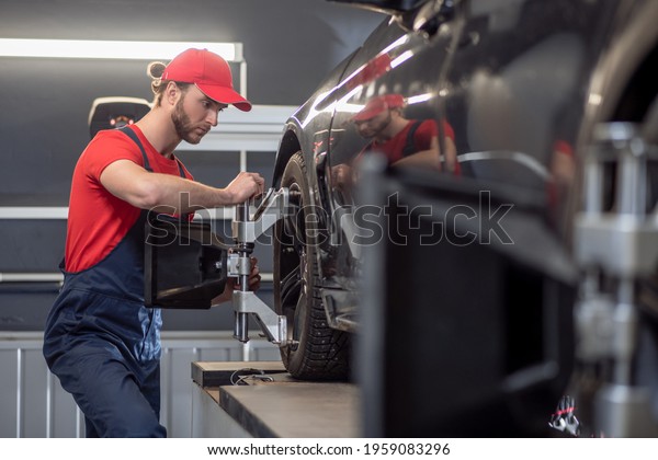 Man in profile repairing\
car wheel