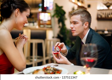 Man proposing to his girlfriend while they are having a romantic date at the restaurant