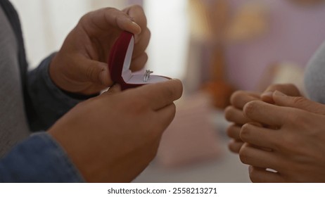 Man proposing to woman with engagement ring in living room, showcasing love and relationship in a home setting, with hands holding a ring box indoors - Powered by Shutterstock