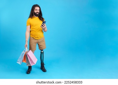 Man with prosthetic leg using the mobile holing shopping bags - Powered by Shutterstock