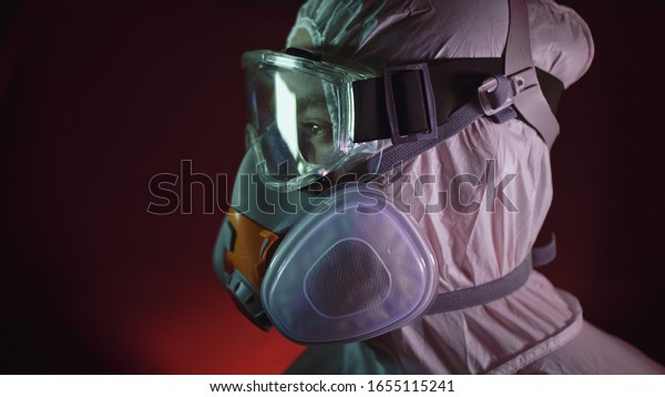 Man in protective costume suit, gas protect medical\
antibacterial antiviral spray paint mask. Doctor health worker in\
respirator. Concept health virus coronavirus epidemic. Radiation\
Nuclear war.