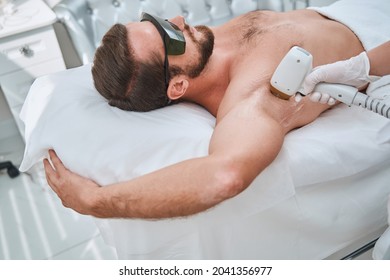 Man In Protective Eyeglasses During A Laser Therapy Session