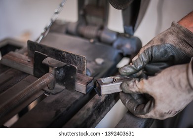 The Man With Protective Gloves Holds The Cut Metal After Grinding