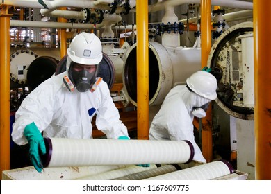 Man With Protective Mask And Protective Clothes In Danger Area. Worker Change The Filter At Oil And Gas Plant.