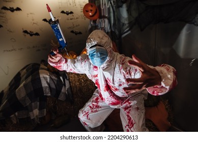 A Man In A Protective Mask On Halloween. Halloween Party During Covid-19. A Man In A Doctor's Suit With A Syringe.