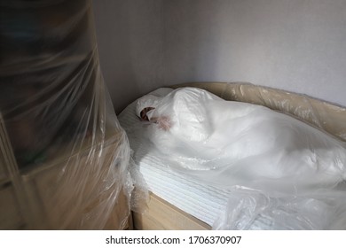 Man In A Protective Medical Suit, Mask And Glasses Seals With Film Furniture, Insanity, Protection From And Repair Dust