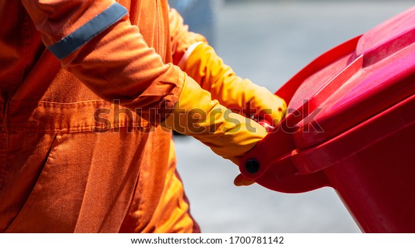 Man in\
protective suit and disposal container for Infectious waste,\
Infectious waste must be disposed in the trash red bag, Coronavirus\
protection equipment in medical waste\
bin.