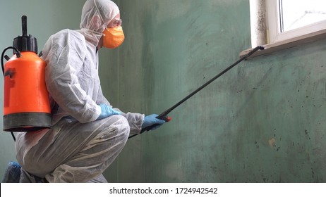 A man in a protective suit, glasses and a respirator sprays a disinfectant. Mold remediation specialist in uniform inspects walls and spraying pesticide on damaged wall with sprayer - Shutterstock ID 1724942542