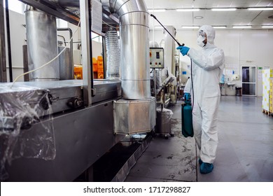 Man in protective suit and mask disinfecting machine for food production from corona virus / covid-19. Warehouse interior. - Shutterstock ID 1717298827