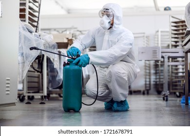 Man In Protective Suit And Mask Disinfecting Warehouse Full Of Food Products From Corona Virus / Covid-19.