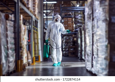 Man in protective suit and mask disinfecting warehouse full of food products from corona virus / covid-19. - Shutterstock ID 1722874114