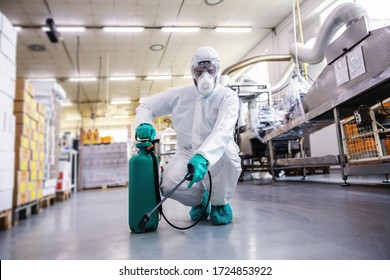 Man In Protective Suit And Mask Disinfecting Food Factory Full Of Food Products From Corona Virus / Covid-19.