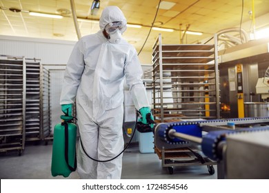 Man In Protective Suit And Mask Disinfecting Warehouse Full Of Food Products From Corona Virus / Covid-19.