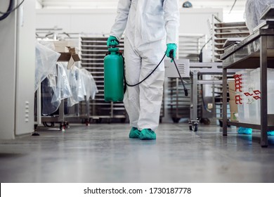 Man in protective suit and mask disinfecting warehouse full of food products from corona virus / covid-19. - Shutterstock ID 1730187778