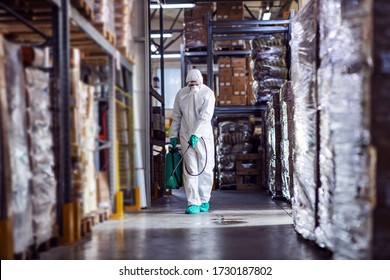 Man in protective suit and mask disinfecting warehouse full of food products from corona virus / covid-19. - Shutterstock ID 1730187802