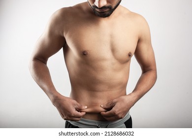 Man Pulling the belly skin, deposition of subcutaneous fat showing body fat.