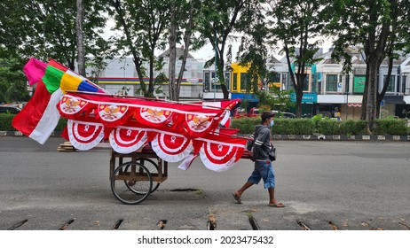a man is pulling a cart selling Indonesian flags, Red and White flags. Jakarta, 12 August 2021.