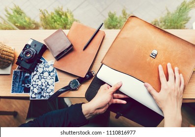 Man pulling out a laptop out of a leather case